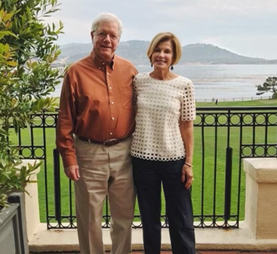 Une femme en toge et coiffe de graduation sourit à la caméra